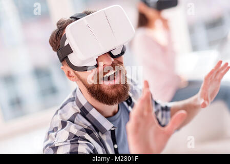 Happy joyful man using VR device Stock Photo