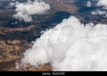Large White Cumulus Clouds seen from Window of Airplane Stock Photo