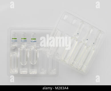 Medical vials with liquid for injection in plastic containers on a white background. The view from the top Stock Photo