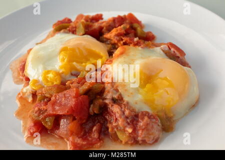 Shakshouka, a popular Middle Eastern dish originating in Tunisia, made of onion, tomato, capsicum, garlic and eggs fried together with the egg added l Stock Photo