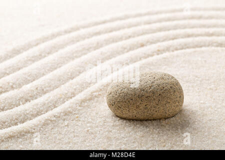 Zen sand and stone garden with raked curved lines with selective focus. Simplicity, concentration or calmness abstract concept Stock Photo