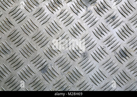 Industrial background of worn, diamond patterned aluminium plate close up. Stock Photo