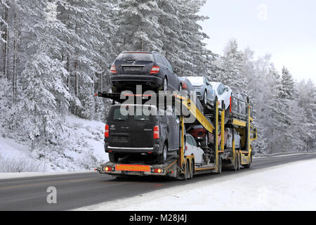 SALO, FINLAND - JANUARY 21, 2018: Scania car carrier of SE Makinen transports cars and vans along rural highway on a cold day of winter, rear view. Stock Photo