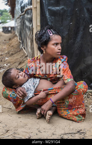Cox's Bazar, Bangladesh. February 6, 2018 - Cox'S Bazar, Bangladesh - A young Rohingya girl and baby sit together in one of the streets of Kutupalong refugee camp in Cox's Bazar. More than 800,000 Rohingya refugees have fled from Myanmar Rakhine state since August 2017, as most of them keep trying to cross the border to reach Bangladesh every day. Credit: Marcus Valance/SOPA/ZUMA Wire/Alamy Live News Stock Photo
