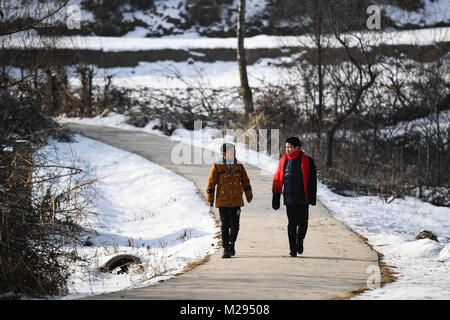 (180206) -- KANGLE, Feb. 6, 2018 (Xinhua) -- Sun Jianjun (R) and his younger brother Sun Jianqiang walk in Xinzhuang Village, Basong Township, Kangle County of northwest China's Gansu Province, Feb. 3, 2018.   Spring Festival, or Chinese Lunar New Year, falls on Feb. 16 this year. Hundreds of millions of Chinese will return to their hometowns for family gatherings.    14-year-old Sun Jianjun and his 15 schoolmates are among these travellers eager back to home. On Feb. 1, the first day of the 2018 Spring Festival travel rush, they stepped onto a train in Nantong of east China's Jiangsu Province Stock Photo