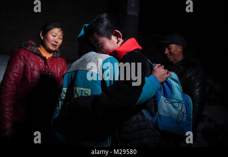 (180206) -- KANGLE, Feb. 6, 2018 (Xinhua) -- Sun Jianjun (R) hugs with his younger brother Sun Jianqiang at home in Xinzhuang Village, Basong Township, Kangle County of northwest China's Gansu Province, Feb. 2, 2018.   Spring Festival, or Chinese Lunar New Year, falls on Feb. 16 this year. Hundreds of millions of Chinese will return to their hometowns for family gatherings.    14-year-old Sun Jianjun and his 15 schoolmates are among these travellers eager back to home. On Feb. 1, the first day of the 2018 Spring Festival travel rush, they stepped onto a train in Nantong of east China's Jiangsu Stock Photo