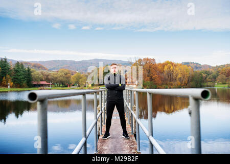 Young sportsman standing on a pier, arms crossed. Stock Photo