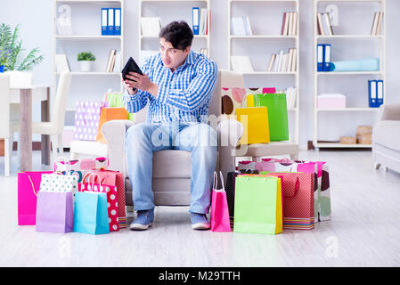 Young man after excessive shopping at home Stock Photo