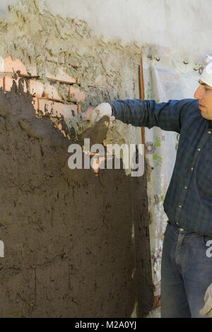 In Ukraine, most people plaster walls with their hands without automatic machines Stock Photo