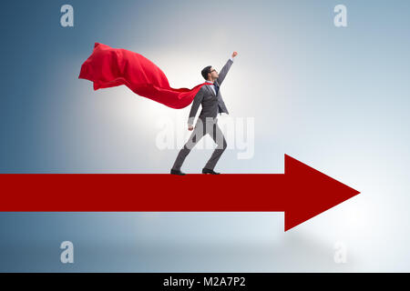 Superhero businessman standing on arrow Stock Photo