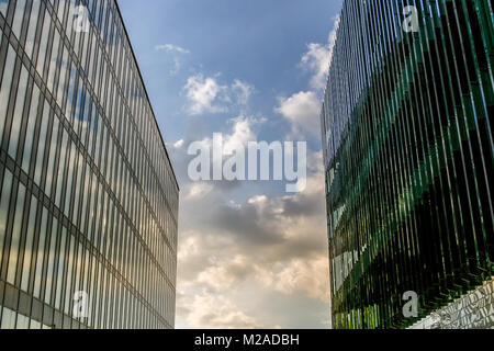 Two large modern buildings stand close to each other, closing the sky. Stock Photo