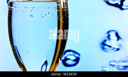 Pouring Clean Water into the Glass on the Blue Background Stock Photo