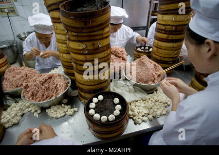 China. Shanghai. Old Town, near Yuyuan Gardens. Women preparing steamed dumplings or dim sum (in steamer baskets). Stock Photo