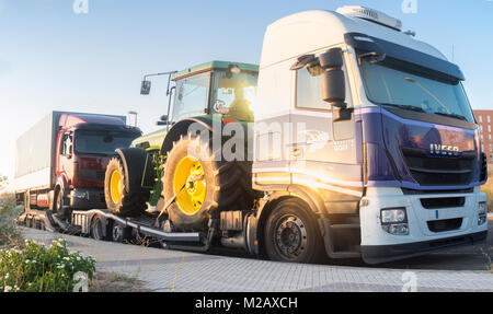 Badajoz, Spain - August 6th, 2017: Iveco Stralis E5 Heavy-duty truck with an auto-transport trailer carrying tractor and semi-trailer truck Stock Photo