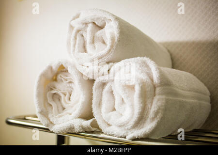 Rolled white towels on a shelf bathroom Stock Photo