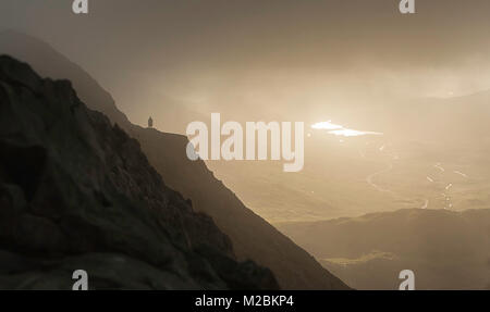 Lone man standing on Crib goch, the exposed ridge walk up to the highest mountain in Wales, second highest in the UK Stock Photo