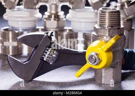 Adjust wrench power grip and elements of water and gas shutoff valves Stock Photo