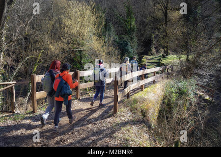 Trevi nel Lazio (FR), Italy - January 28, 2018: Group of hikers crossing a country path, passing over a bridge with a wooden fence. Stock Photo