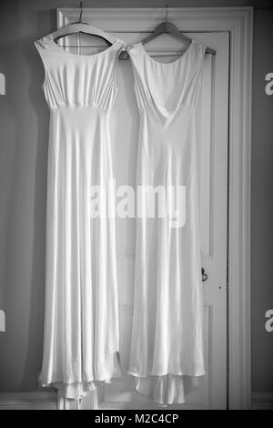 Two wedding dresses hanging on door frame Stock Photo