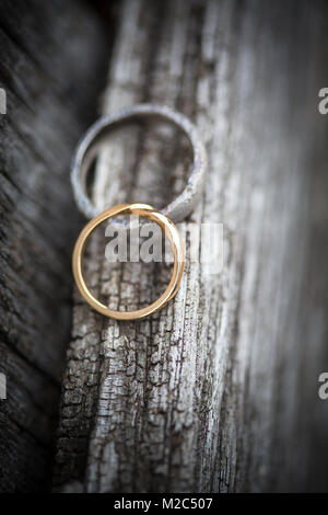 Two wedding rings on wooden surface, close-up Stock Photo