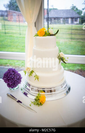 Three tiered celebration cake decorated with fresh flowers Stock Photo