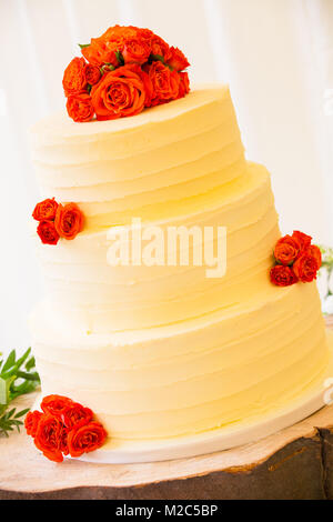 Orange roses on top of three tiered celebration cake Stock Photo
