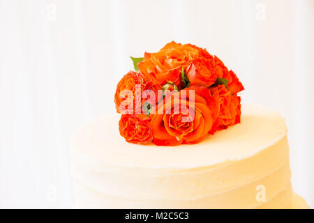 Orange roses on top of celebration cake, close-up Stock Photo