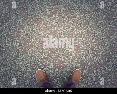 Man shoes on urban asphalt grunge background with copy space. Conceptual image of legs in boots outdoor on city street. Stock Photo