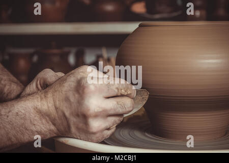 elderly man making pot using pottery wheel in studio Stock Photo