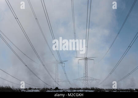 High voltage power lines on foggy morning. Stock Photo