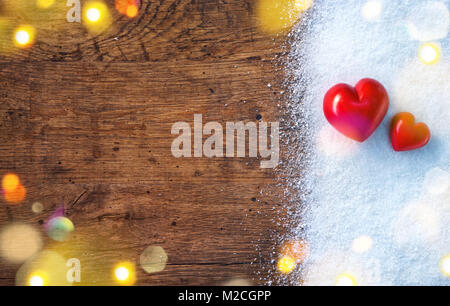 Two red hearts on snow and rustic background. Love and St. Valentines Day concept. Stock Photo