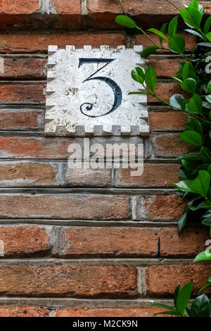 House number three, 3. In front of an ancient luxury residential apartment building in the Coppede quarter. Art Deco style. Rome, Italy, EU. Close up. Stock Photo