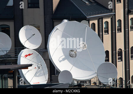 COMMUNICATION: Many roof top salletelite dishes used for communication receiving radio waves. Stock Photo