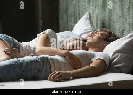 Young couple enjoying sleep on daytime lying in bed together  Stock Photo