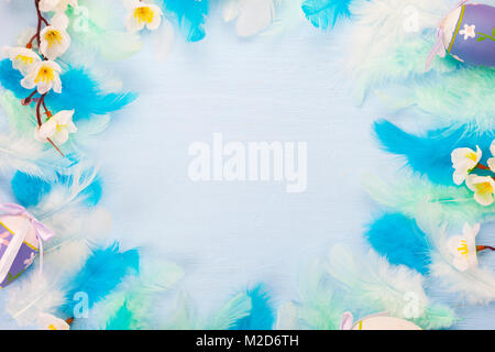 Easter eggs, feathers and flowers on color wooden background. Easter still life with flowers, nest, feathers and eggs. Stock Photo