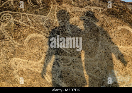 Two fugure on a stone with big petroglif in the open air Historical Museum of Kyrgyzstan. Stock Photo