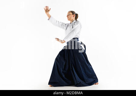 Aikido master practices defense posture. Healthy lifestyle and sports concept. Woman in white kimono on white background. Stock Photo