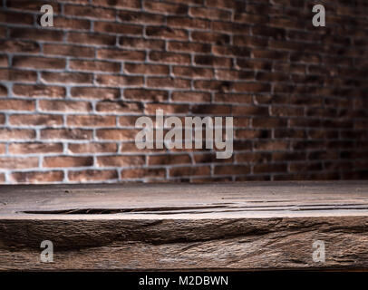 Old wooden empty table and brick wall in the background. Stock Photo