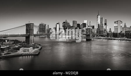 Sunrise on Lower Manhattan and the Brooklyn Bridge in Black & White. Financial District skyscrapers with East River. New York City Stock Photo