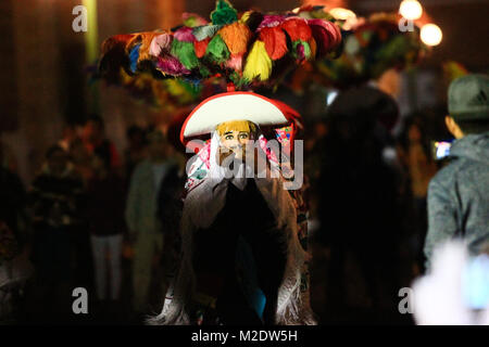 Horizontal photo of a Carnival scene, a dancer wearing a traditional mexican folk costume and mask looking right into the camera Stock Photo