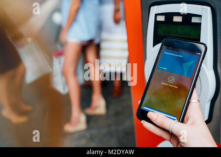 Hand of woman paying at kiosk using cell phone Stock Photo