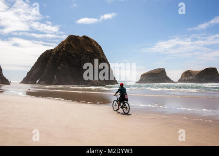 Caucasian woman riding bicycle on beach Stock Photo