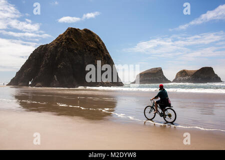 Caucasian woman riding bicycle on beach Stock Photo