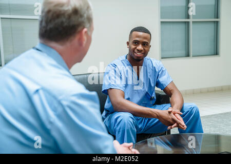 Doctor and nurse talking in lobby Stock Photo