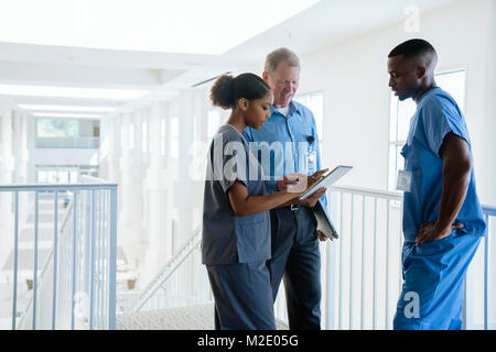 Doctor and nurses using digital tablet near staircase Stock Photo