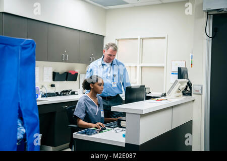 Doctor and nurse using computer in hospital Stock Photo