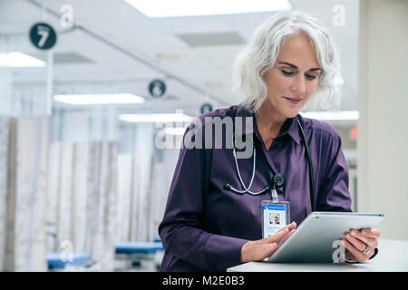 Caucasian doctor using digital tablet in hospital Stock Photo