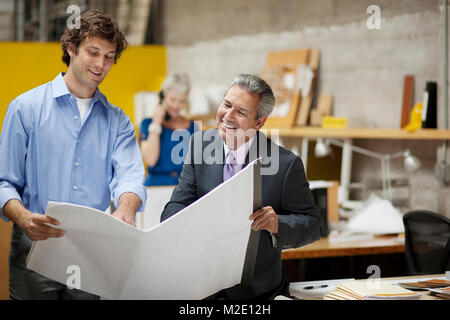 Architects reading blueprints in office Stock Photo
