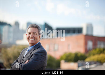 Portrait of smiling Hispanic businessman posing outdoors Stock Photo