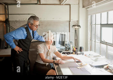 Business people examining parts in office Stock Photo